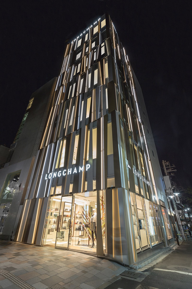 夜晚時分，Longchamp表參道旗艦店建築外部不規則的直線燈光輕輕地閃爍、躍動，為城市帶來生命力